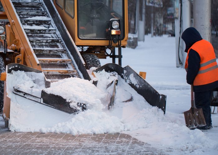Tractor cleaning the road from the snow. Excavator cleans the streets of large amounts of snow in